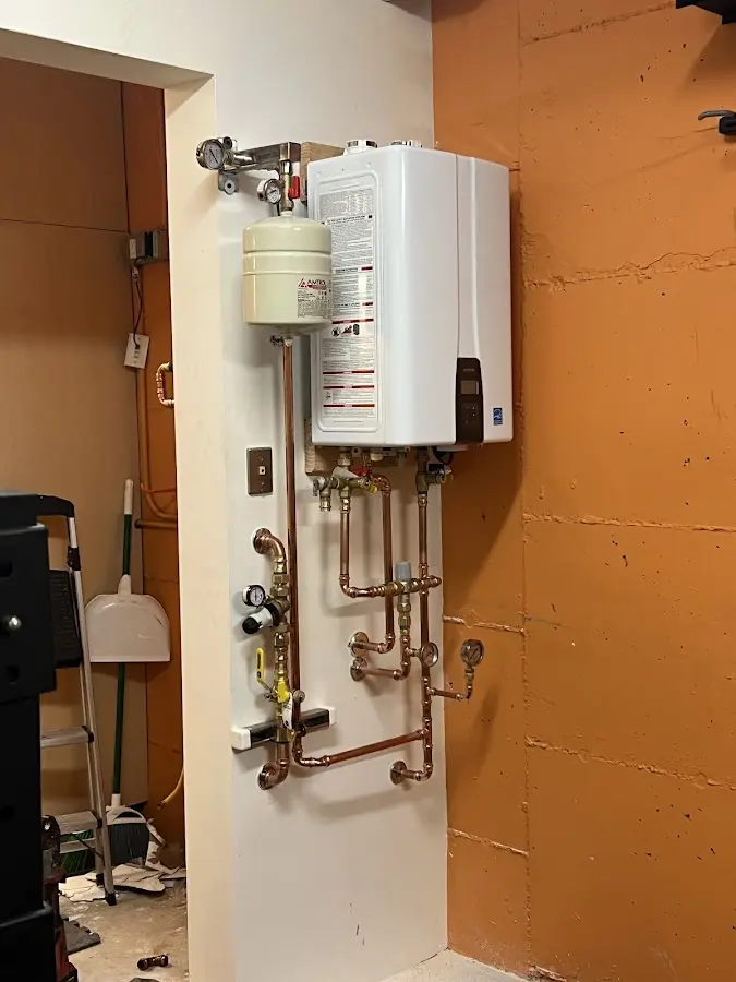 Plumbing technician inspecting water heater connections in Nether Providence
